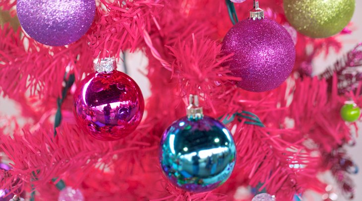 IMAGE: Blue, pink, and purple holiday bulbs hang on a bright pink tree