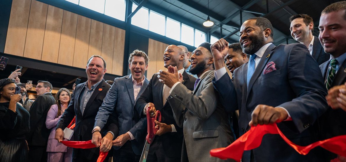 Mayor Scott cuts celebritory ribbon with Governor Wes Moore, Baltimore City Coucil President Nick Mosby and other city leaders at the re-opening of Lexington Market